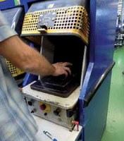 Ein scheinbar normaler Arbeitsschritt: Ein Mitarbeiter legt einen Schuh in die Aufnahmeplatte der Sohlenklebepresse und betätigt damit den Endschalter, der den Pressvorgang auslöst. Sekundenschnell korrigiert er noch einmal die Position des Schuhs. Wenn das Auflegen länger dauert, sorgt die voreilende Schutzhaube für eine Unterbrechung des Pressvorgangs. In diesem Fall lief alles anders.