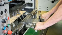 Auszeichnung: Diverse Arbeiten an Stanzen erfordern es, sogenannte Ausbrechrahmen herauszuziehen. Feste Griffe sind von Herstellern nicht vorgesehen, weshalb Quetschungen drohen. Abhilfe leisten diese fest verschraubten Zweier-Griffe.